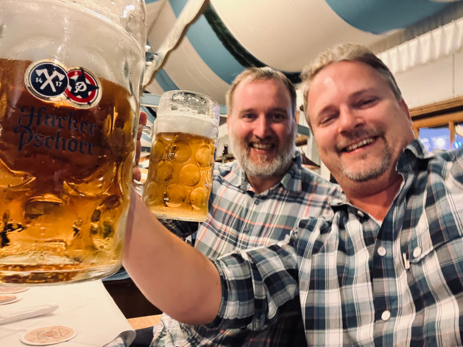 Två klubbmedlemmar tar en selfie och skålar med öl