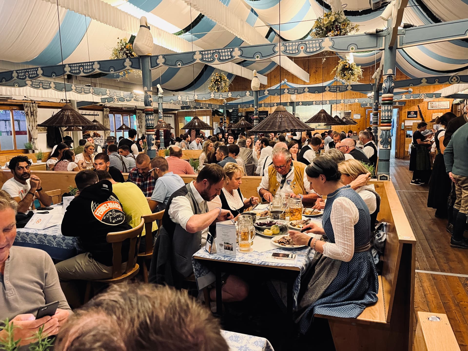 Fullsatt ölhall med traditionell bayersk inredning