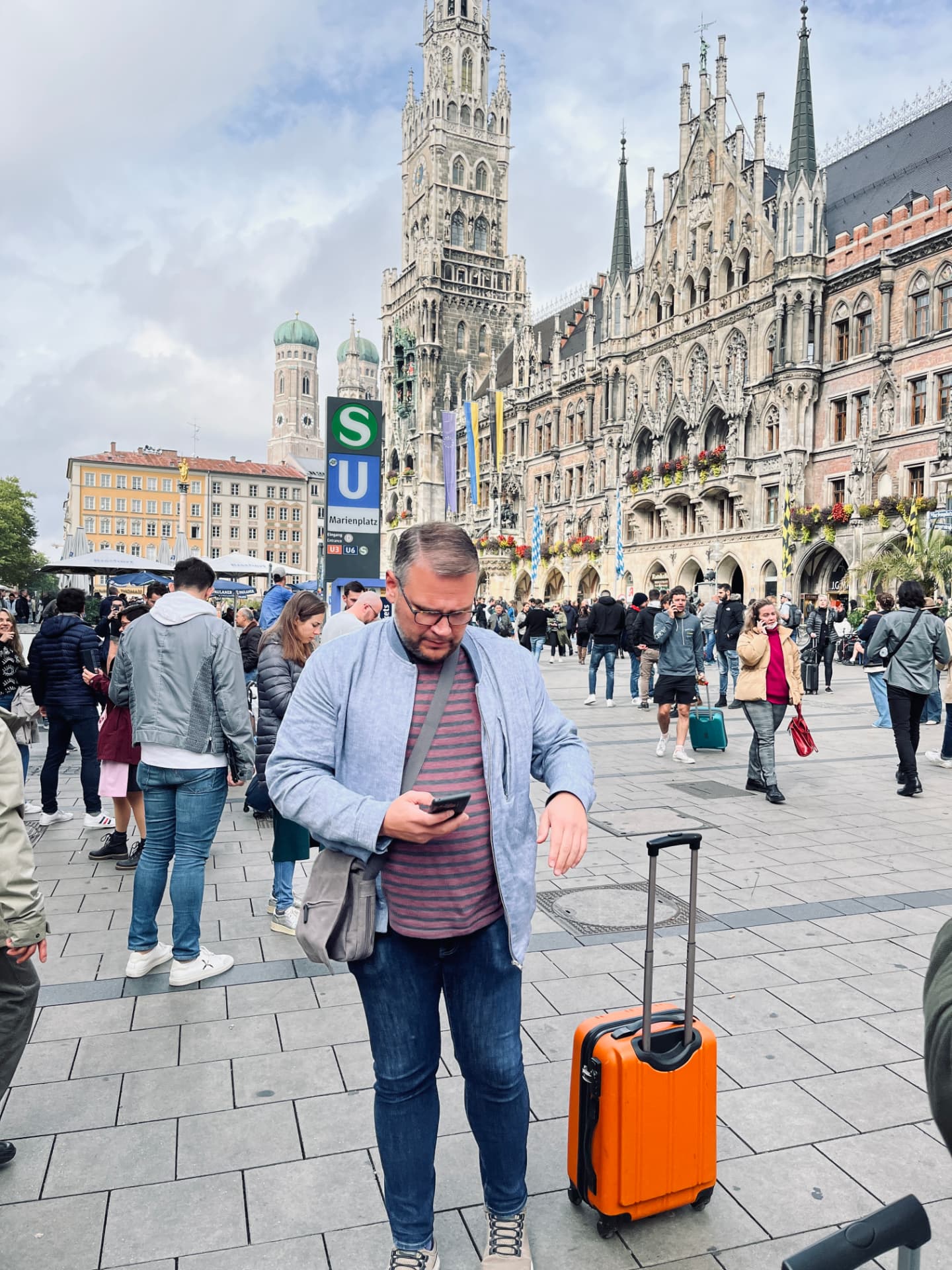 En klubbmedlem med resväska på Marienplatz i München
