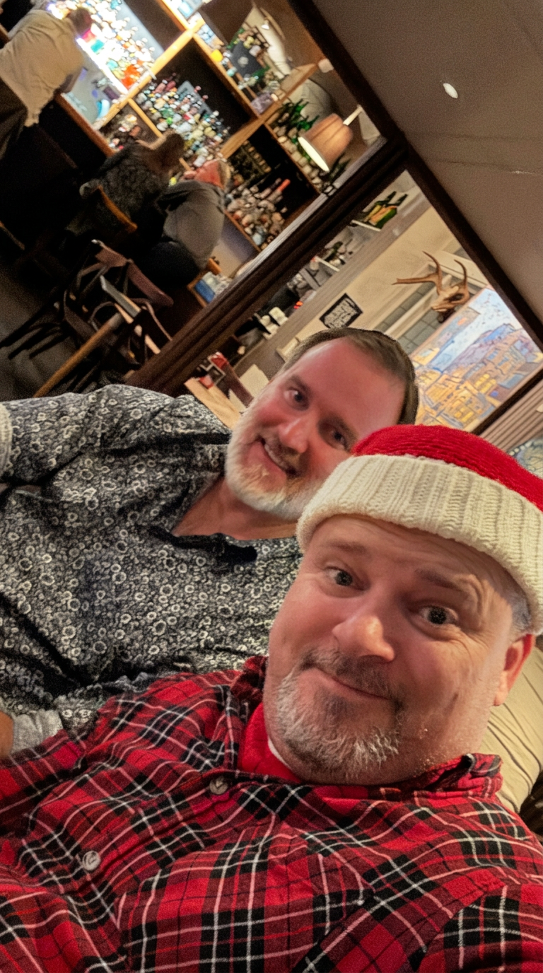 Två klubbmedlemmar tar en selfie på restaurang, den ena i tomteluva
