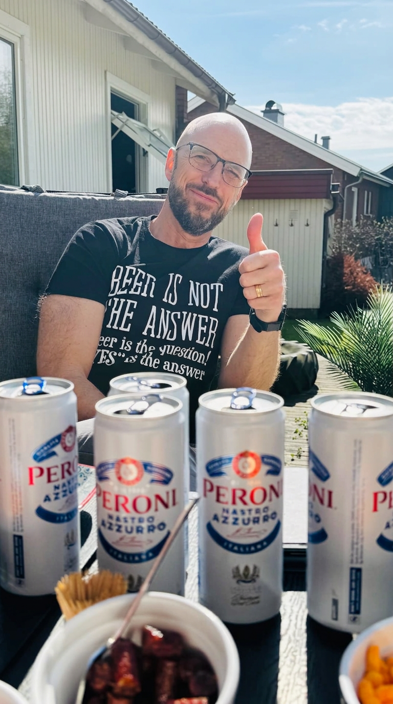 En klubbmedlem gör tummen upp bakom flera Peroni-burkar