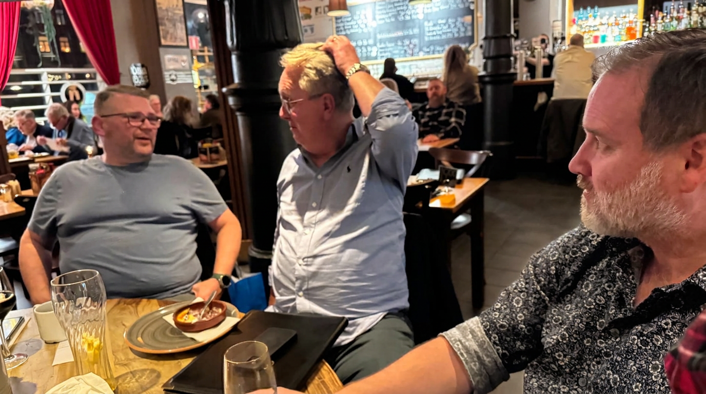 Tre klubbmedlemmar i samtal runt ett restaurangbord