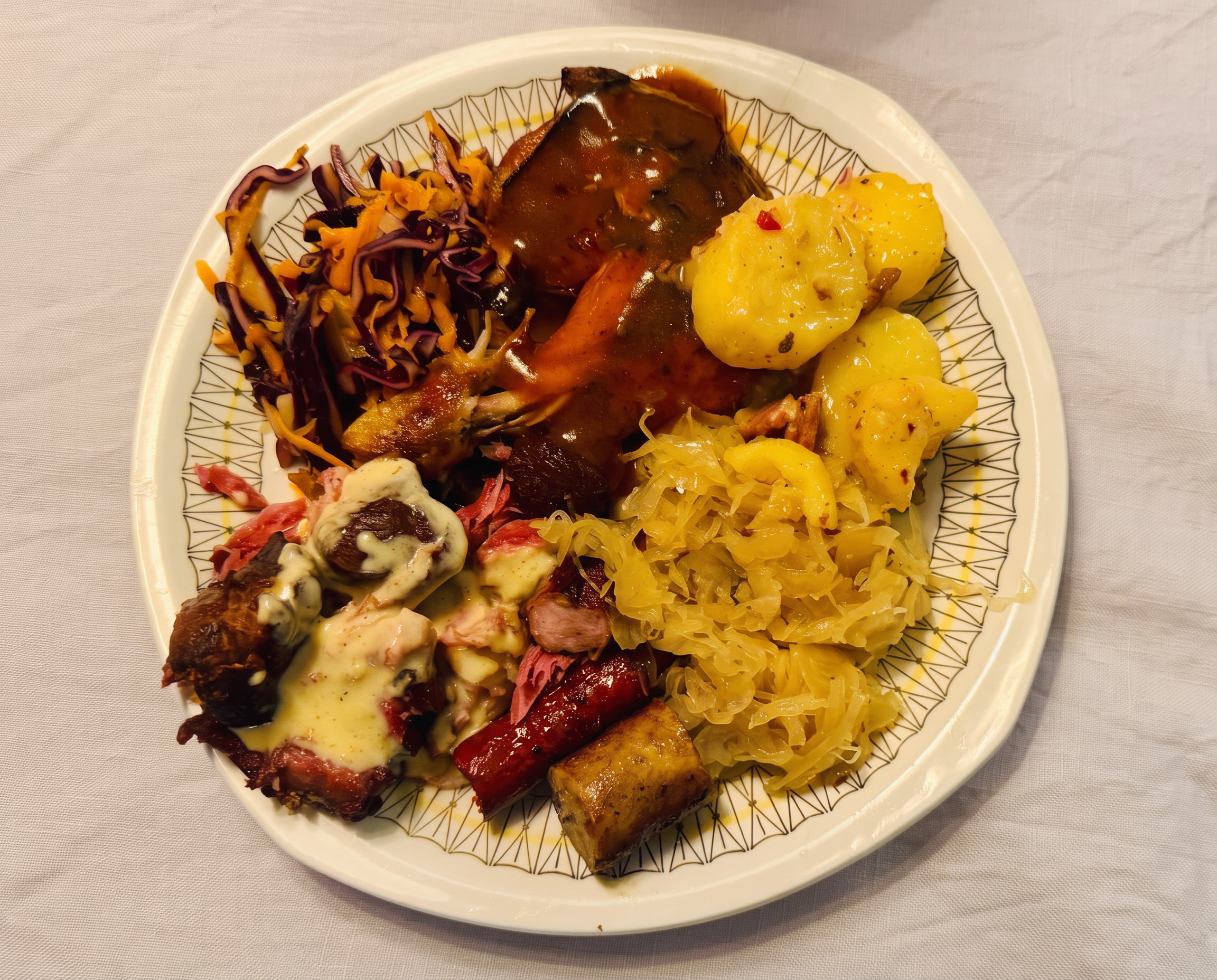 En fylld tallrik med kött, korv, potatis, sallad och surkål