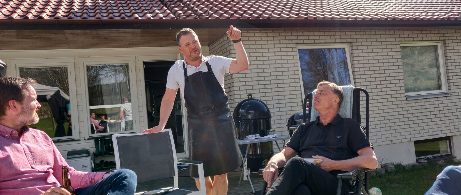 Klubbmedlemmar samlade utomhus vid grillen